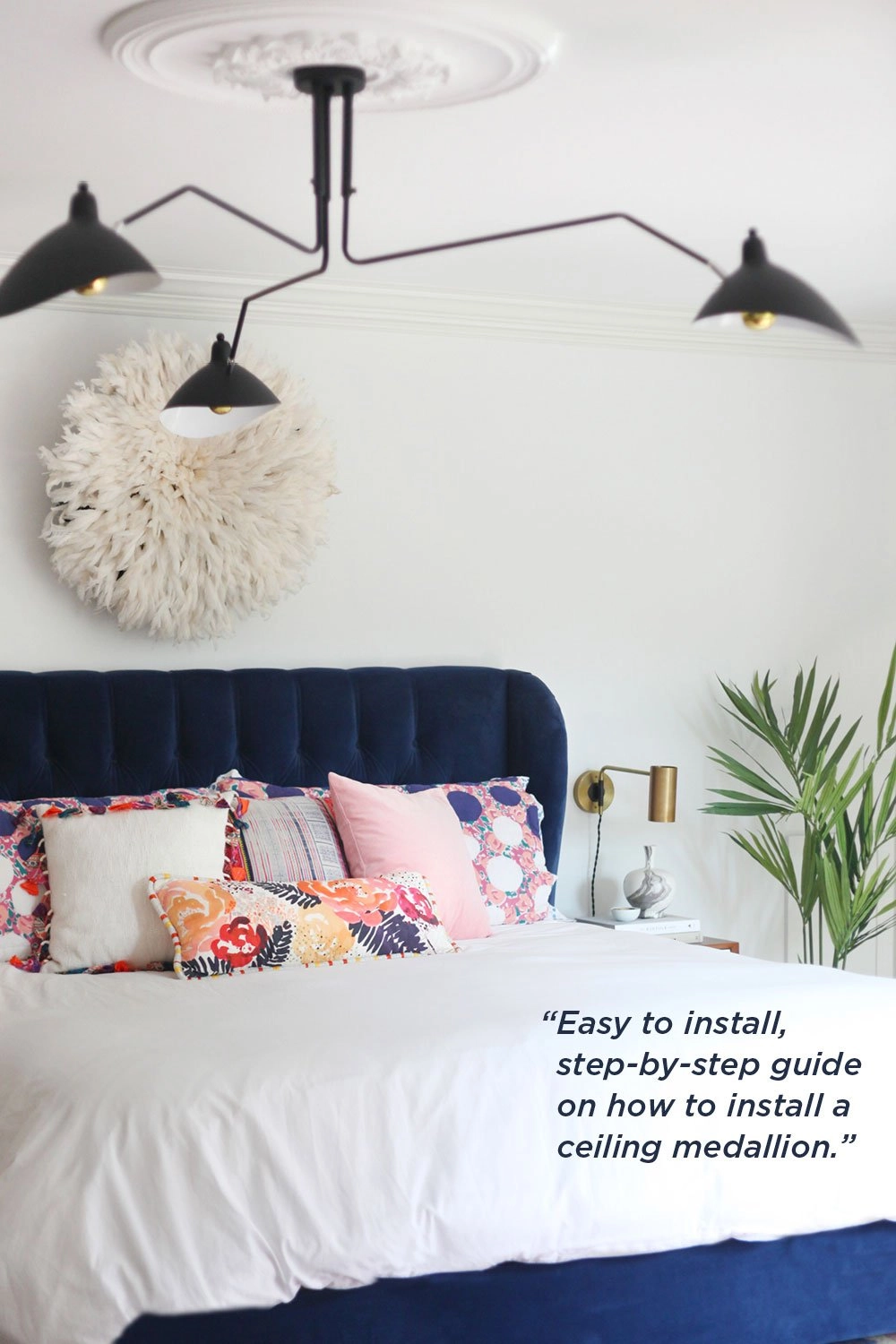 Modern light fixture paired with a traditional ceiling medallion in an eclectic bedroom